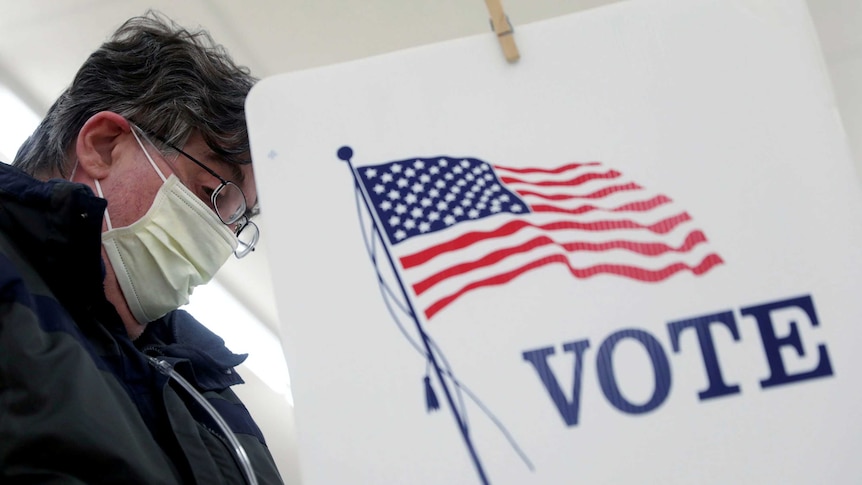 Voter Fred Hoffman fills out his ballot during the primary election in Ottawa, Illinois