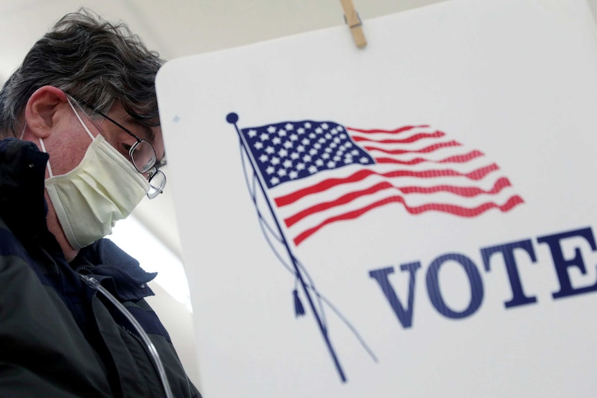 Voter Fred Hoffman fills out his ballot during the primary election in Ottawa, Illinois