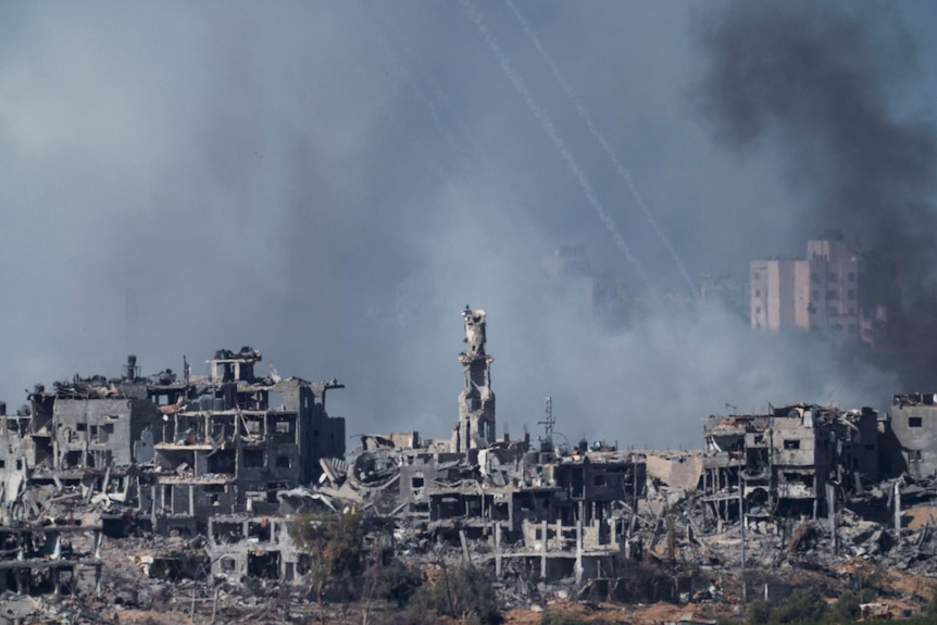 smoke rises above a decimated landscape of buildings  all reduced to rubble