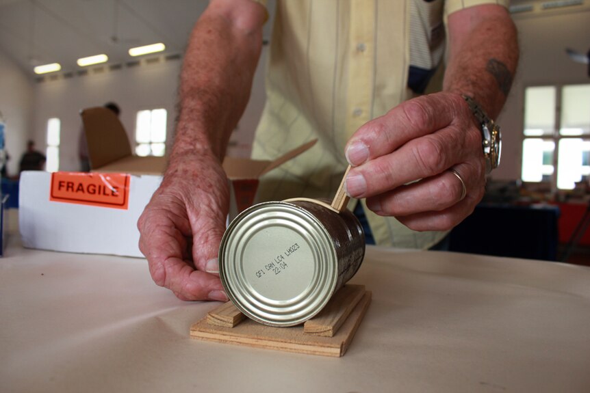 Mr Richardson bends wood on a old cat food tin