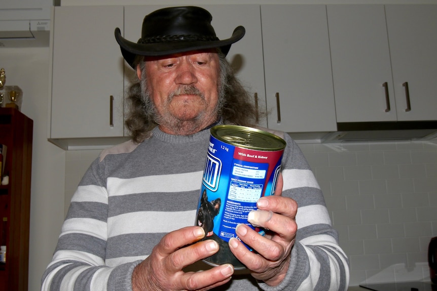 A man holding a can of Chum dog food.