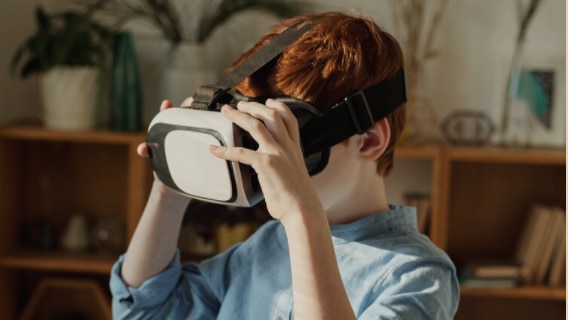 young boy standing with virtual reality headset on