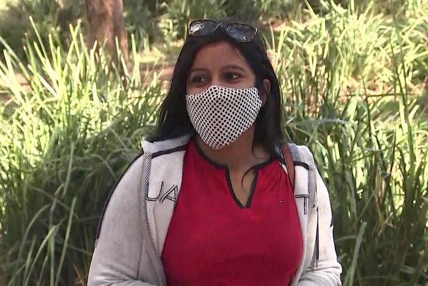 a woman with a red top wearing a face mask over her mouth