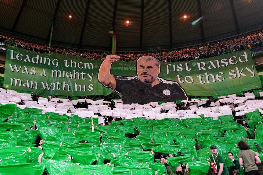 A banner of Ange Postecoglou with the phrase, leading them was a mighty man with his fist raised to the sky