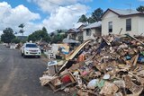 Flood-damaged belongings are piled up on a Lismore street.