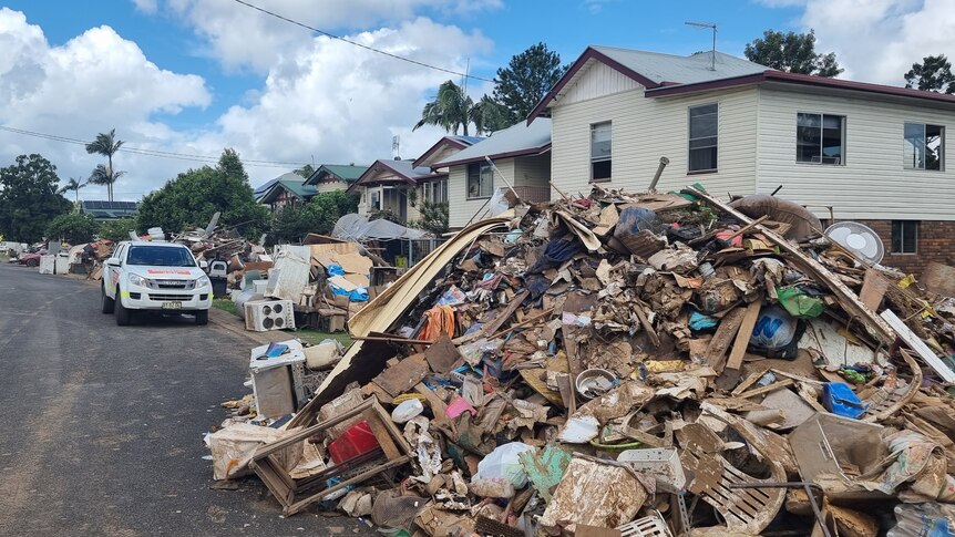 Flood-damaged belongings are piled up on a Lismore street.