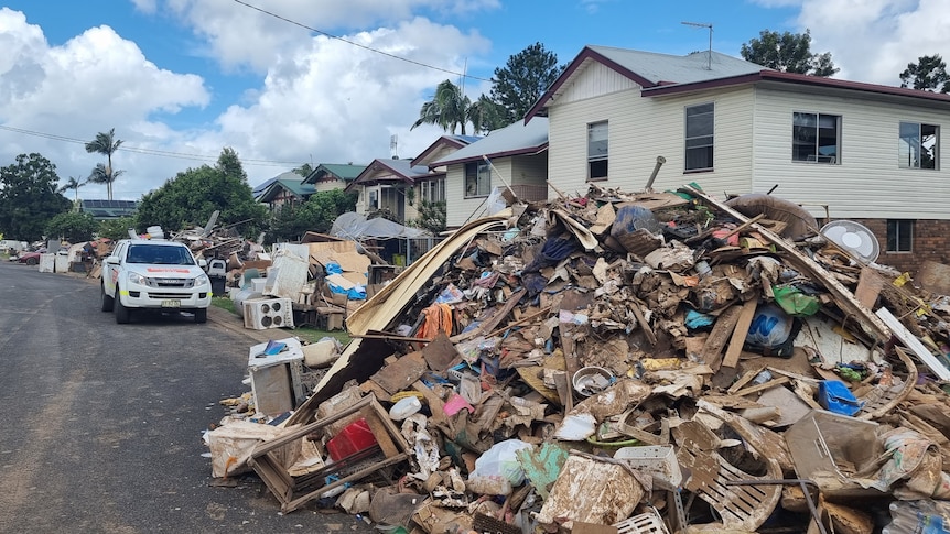 Flood-damaged belongings are piled up on a Lismore street.