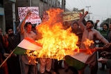 Pakistan protesters burn a representation of an Indian flag.
