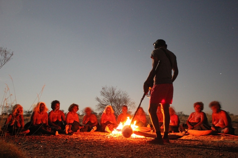 A group of people sitting around a fire