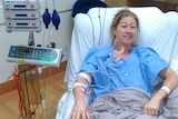 A woman recovering from surgery in a hospital bed