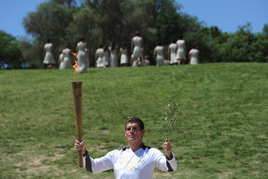 The start of something special ... Greek swimming champion Spyros Gianniotis holds the torch at ancient Olympia.