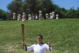 The start of something special ... Greek swimming champion Spyros Gianniotis holds the torch at ancient Olympia.