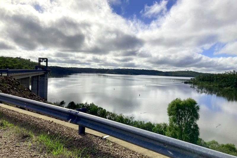 Cliff edge overlooking a mid full dam 