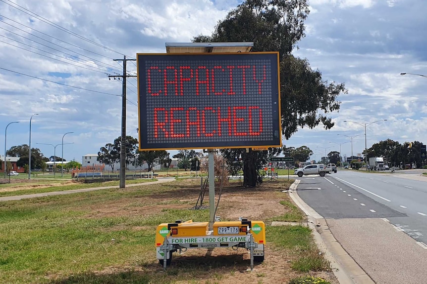 A sign on a roadside reads "Capacity Reached"