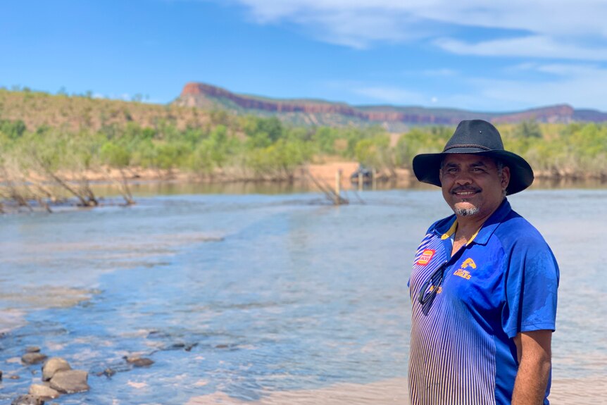 Ronnie Morgan in front of a river and a red mesa cliff formation in background