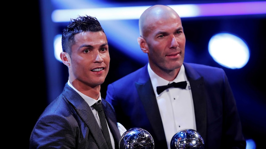 Cristiano Ronaldo and Zinedine Zidane hold up their trophies.