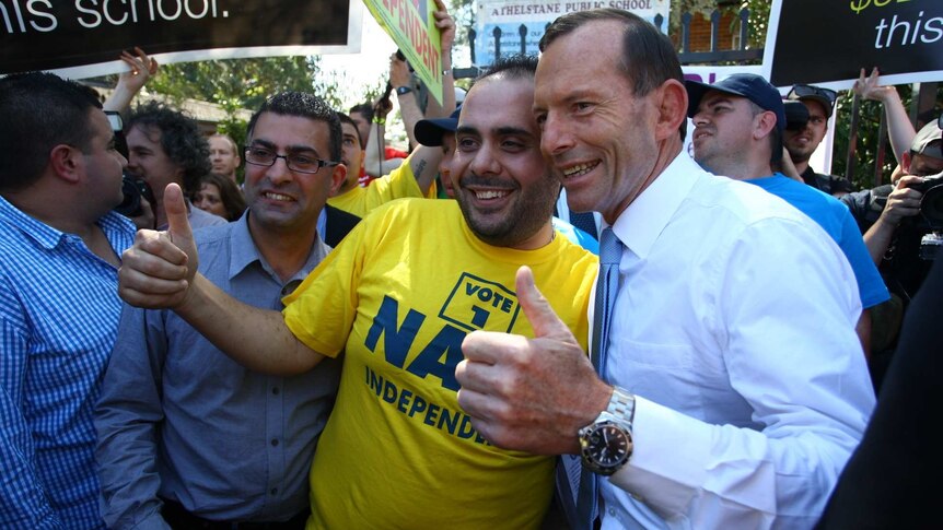 Opposition Leader Tony Abbott takes a photo with an independent supporter in Arncliffe on election day