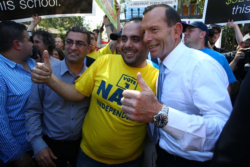 Opposition Leader Tony Abbott takes a photo with an independent supporter in Arncliffe on election day