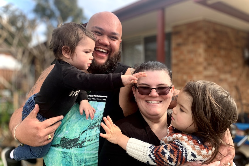 a man and a woman with two laughing children