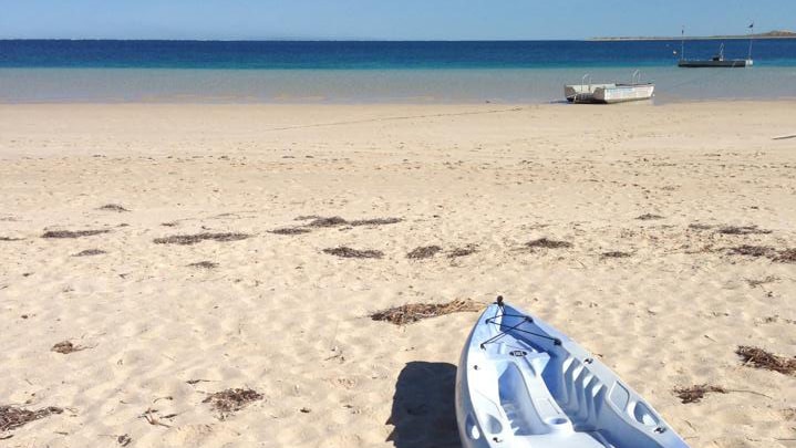 A kayak rests on sand at Coral Bay in WA's Gascoyne