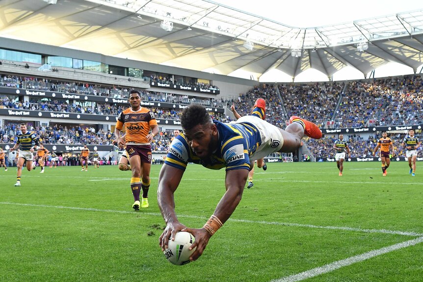 An NRL player dives through the air to score a try in the corner in an Elimination Final.