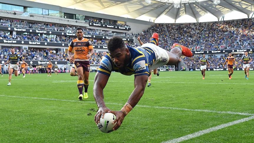 An NRL player dives through the air to score a try in the corner in an Elimination Final.