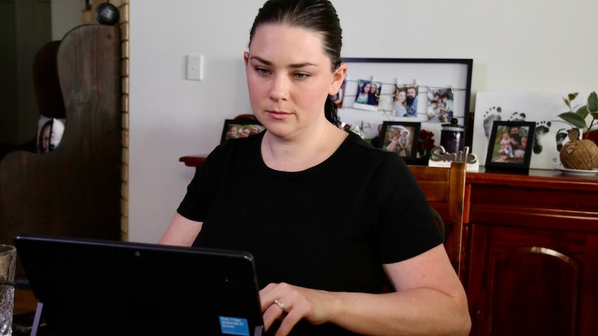 A woman uses a laptop in her home.