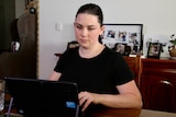 A woman uses a laptop in her home.