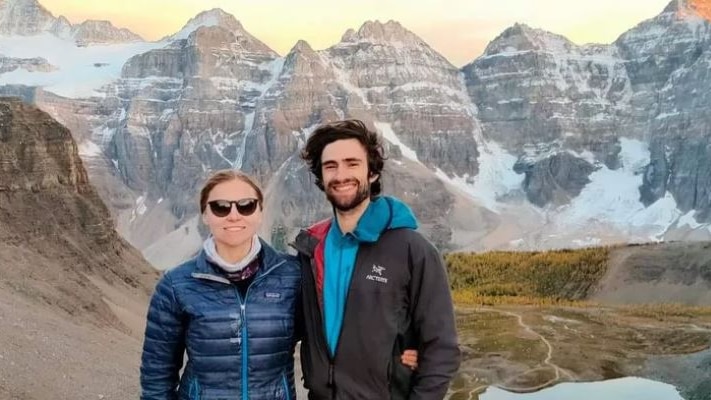 A woman and a man standing among mountains