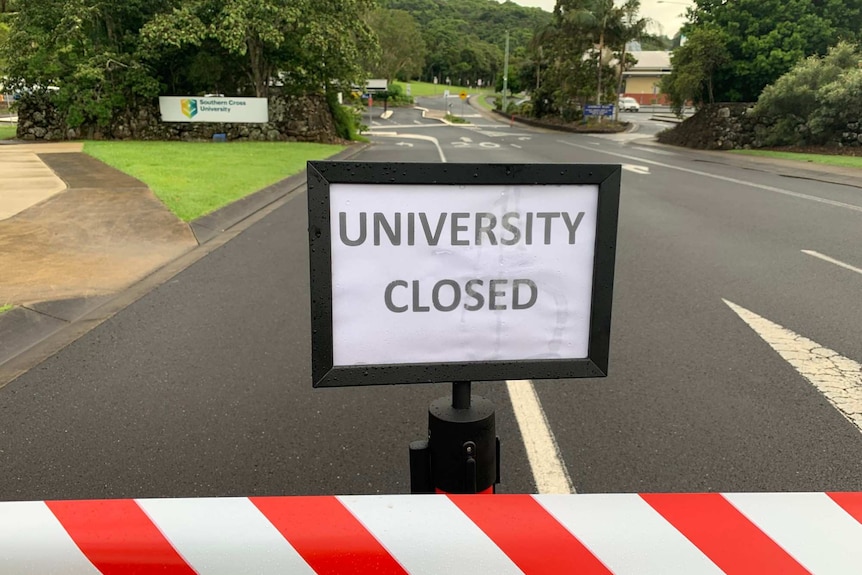 Sign in middle of road that reads 'University Closed'