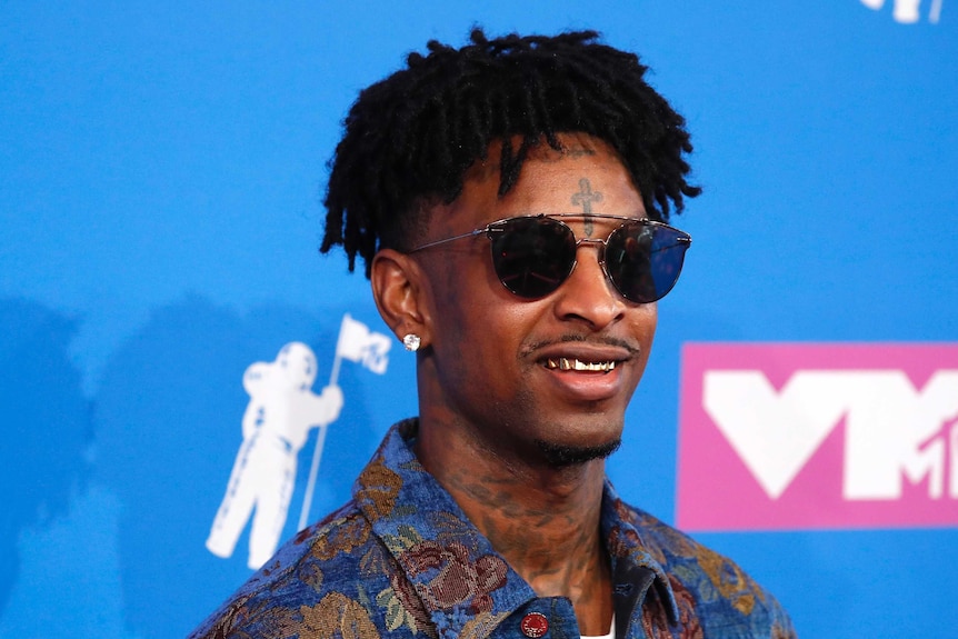 21 Savage smiles in sunglasses