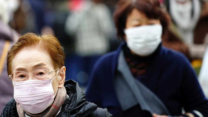 An elderly lady with glasses and another woman can be seen wearing masks.