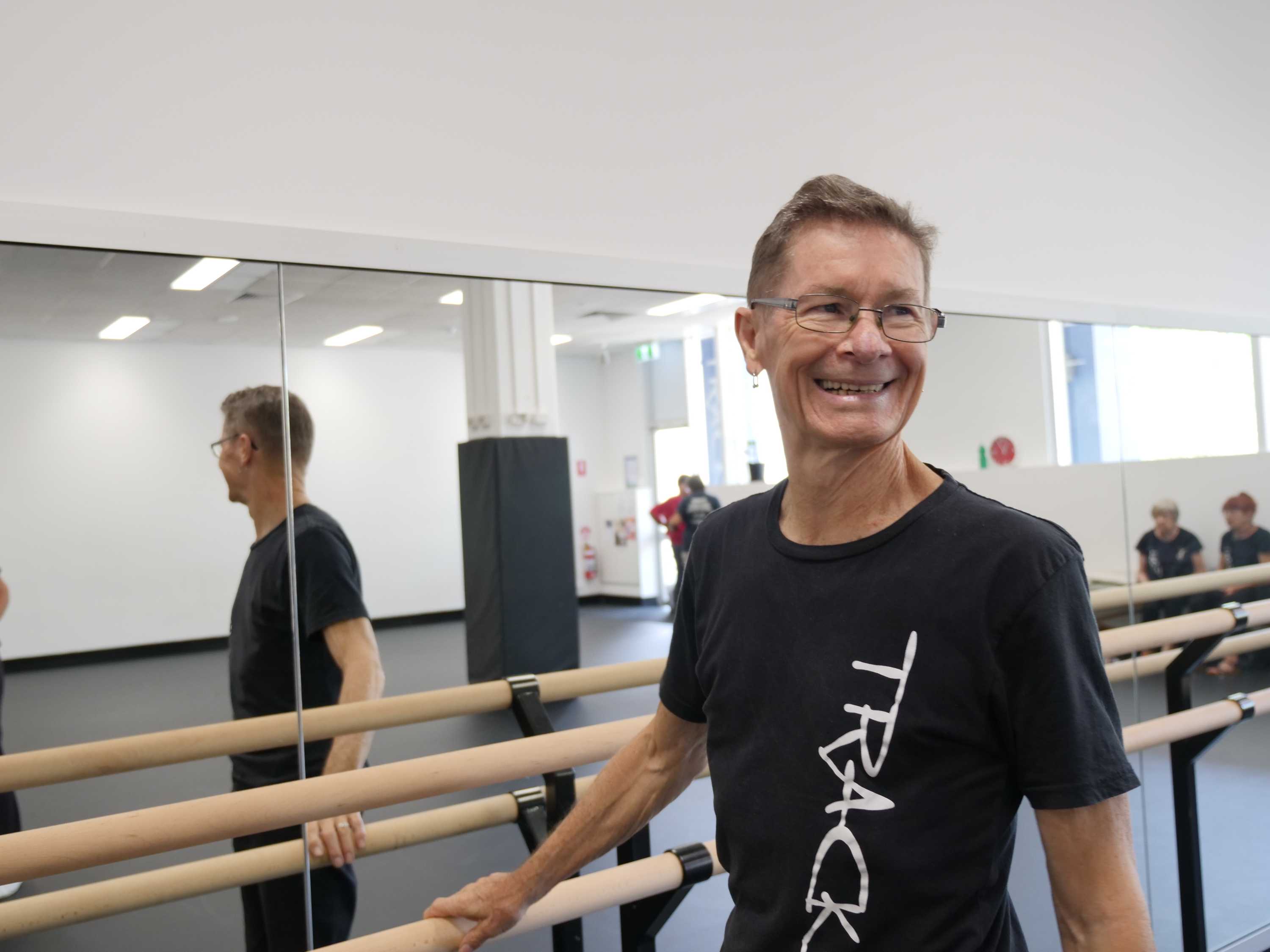 Darryl Butler, 72, standing at ballet bar in dance studio.