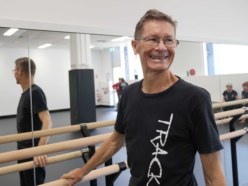 Darryl Butler, 72, standing at ballet bar in dance studio.