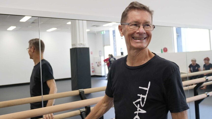 Darryl Butler, 72, standing at ballet bar in dance studio.