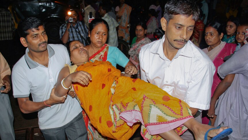 A woman injured by a stampede after the quake is carried to a hospital