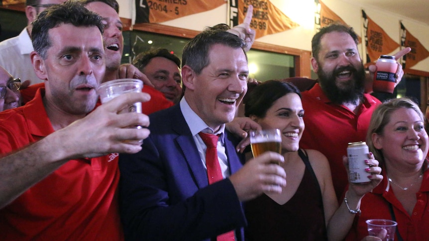 Michael Gunner drinks a beer with party faithful at his victory party in Darwin.