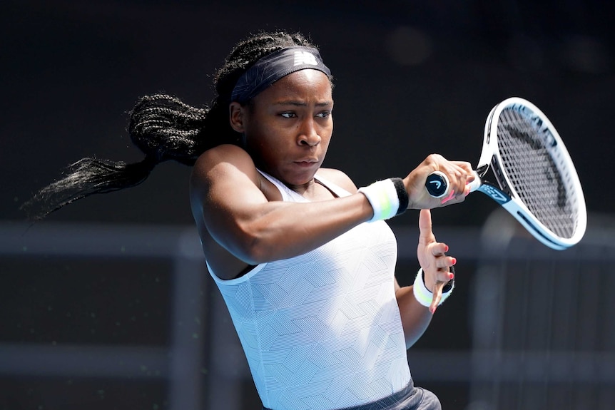 Coco Gauff leans back and hits a shot