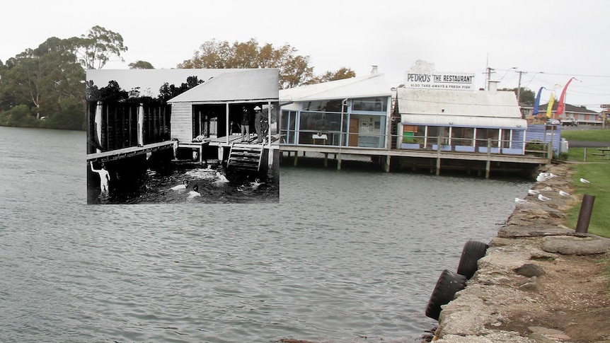 An old photo of the Leven River baths at Ulverstone is held up. Background consists of restaurant on the river's edge.