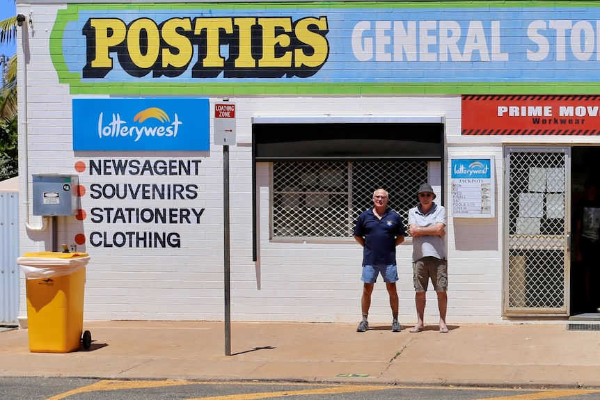 Two men standing in front of Posties General Store.