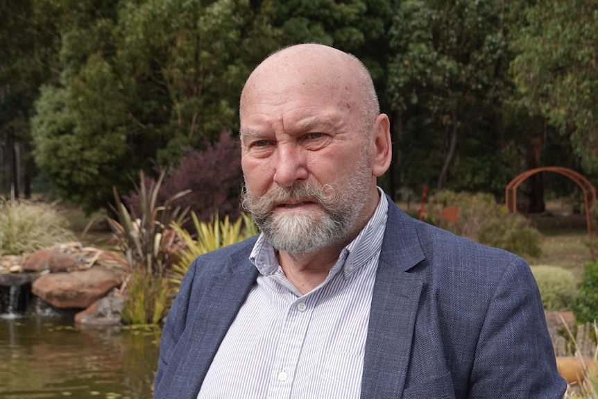 A man wearing a suit and looking serious.