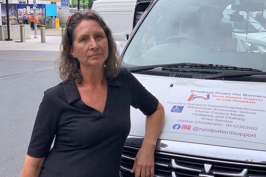 A woman standing next to a car.