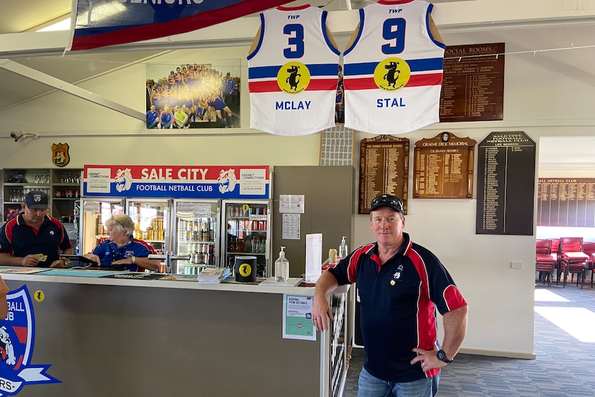 Greg Robinson stands under the Aussie rules guernseys of McClay and Stal at the Sale City bar.