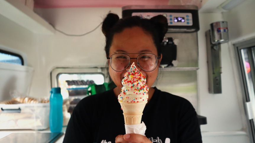 Woman holding a soft service ice cream with sprinkles.