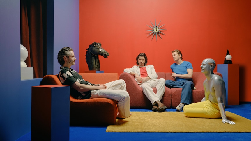 A photo of Mildlife members sitting on armchairs in a red room