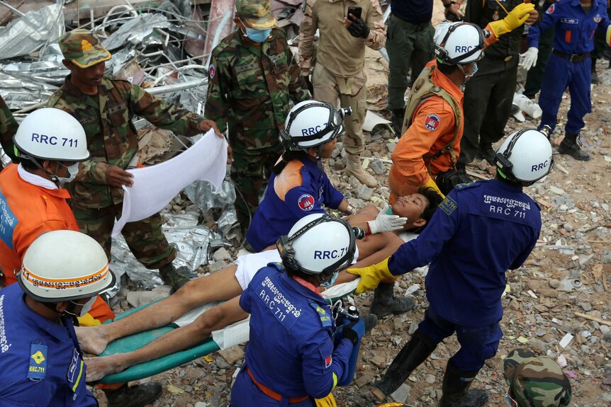 A survivor is carried out of the rubble from a collapsed building in Sihanoukville, Cambodia.