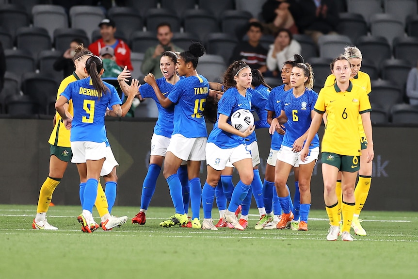 Los jugadores de Brasil celebran mientras los jugadores australianos se van con expresiones neutrales en sus rostros