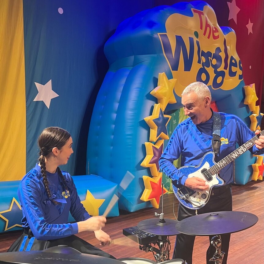 Anthony Field performing guitar as the blue Wiggle alongside daughter Lucia playing drums