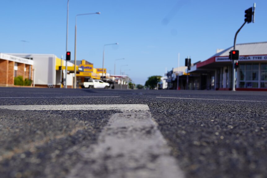 A road marker is in focus while a country street is out of focus