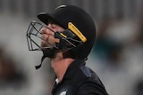 A New Zealand batter walks off the field holding his bat at the men's T20 World Cup.